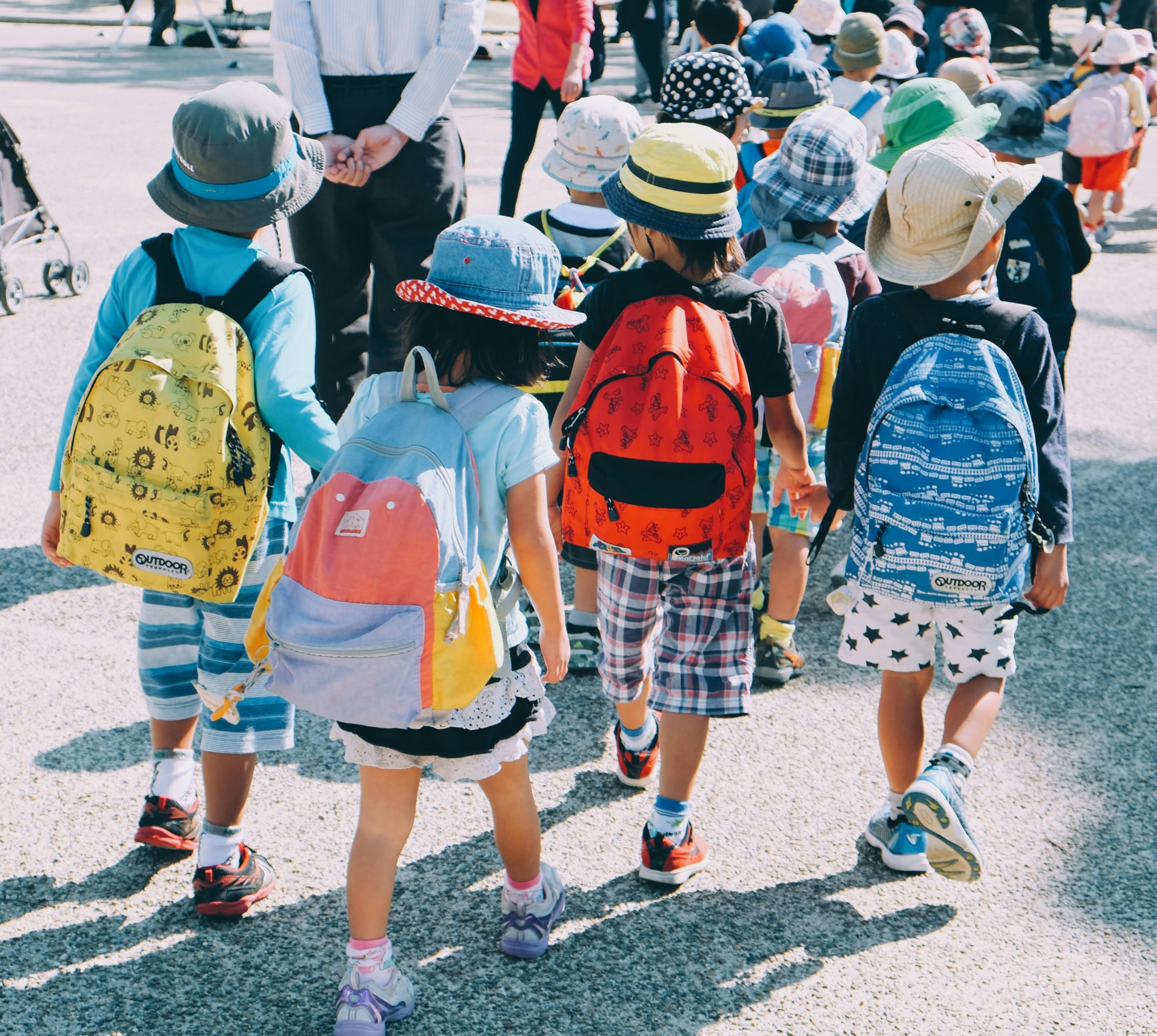 Young children with colourful backpacks walking together